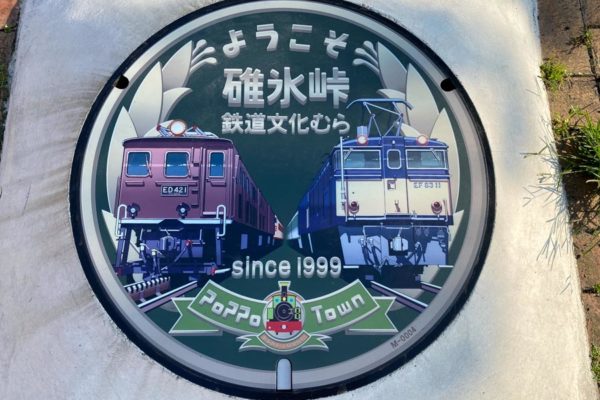 Trains on manhole cover in Poppo Town